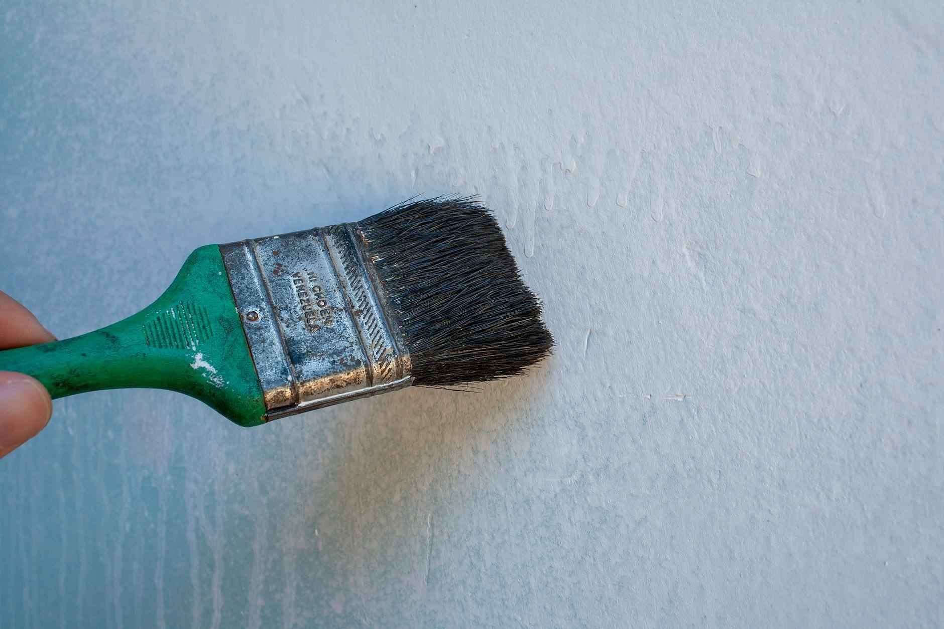 Pared de salón con textura rugosa siendo lijada y alisada por un operario profesional