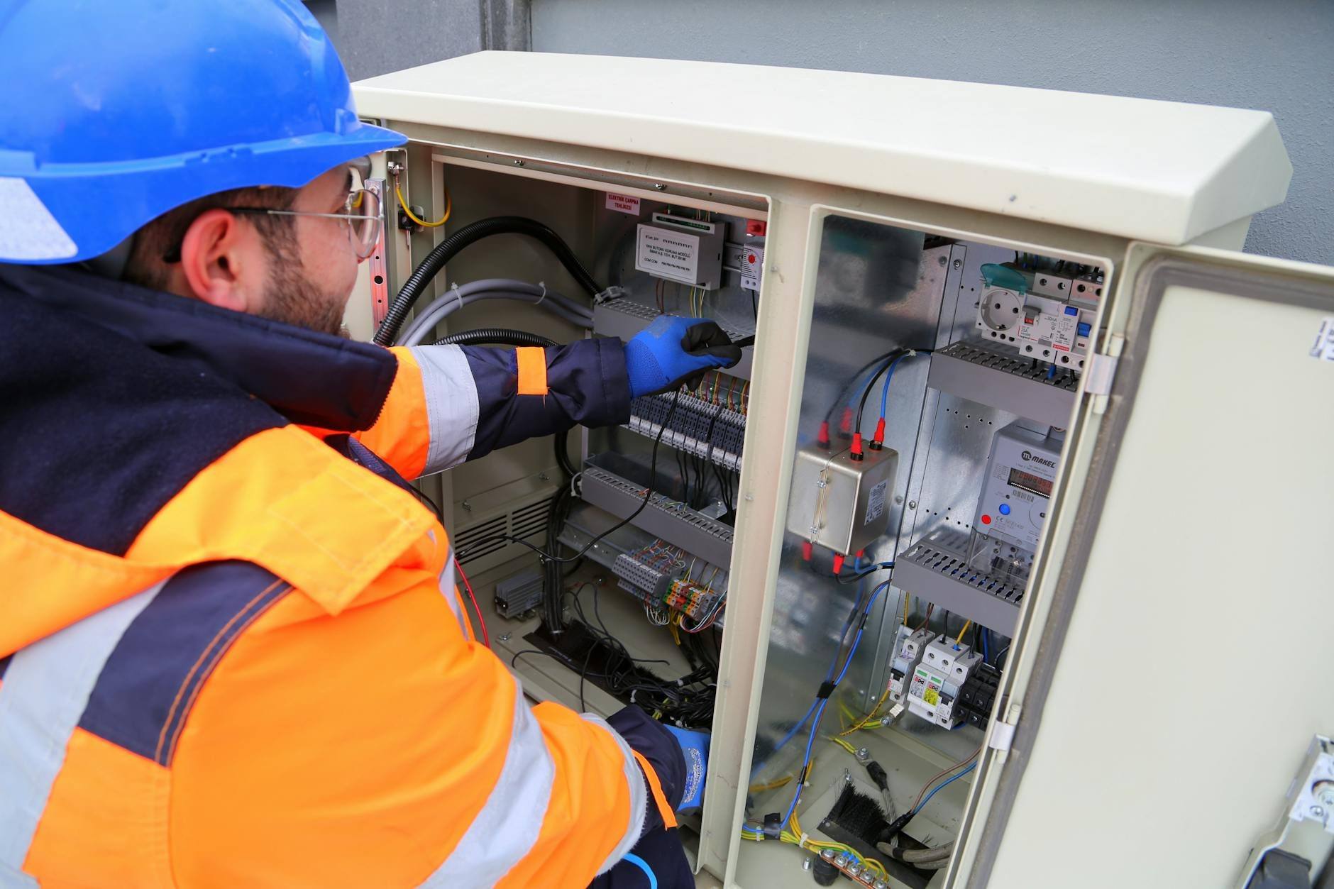 Electricista profesional trabajando en un cuadro eléctrico en una vivienda moderna