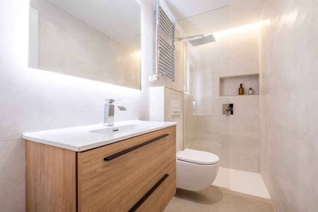 Bano reformado con mueble de madera y ducha a ras de suelo