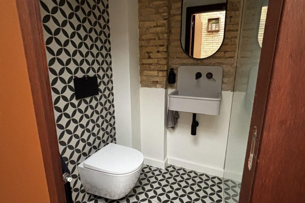 Bano con azulejos geometricos y ladrillo visto en local wellness Zaragoza